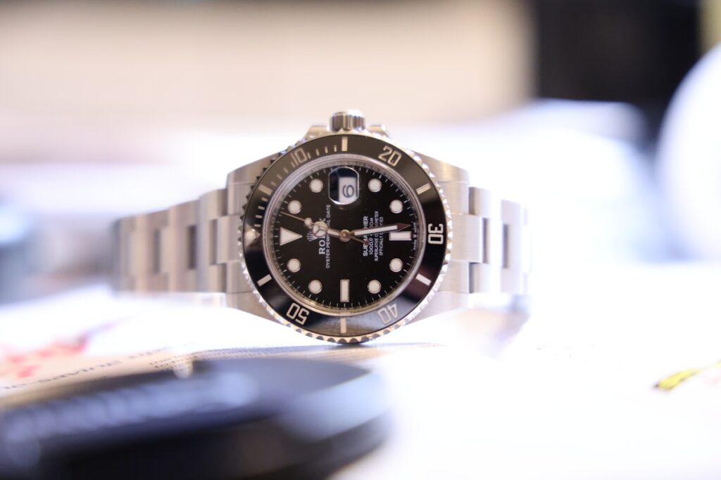 一隻放在桌上的 Rolex 手錶，象徵奢侈消費與財務思維的省思